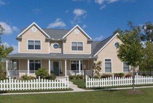 Beige residential home with white picket fence.