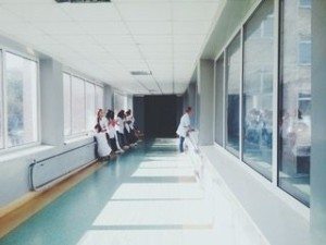 Doctors leaning against a wall in a hospital hallway.