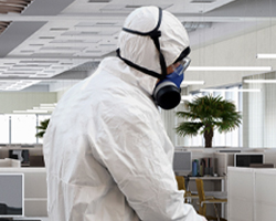 Man in personal protective equipment in an office.